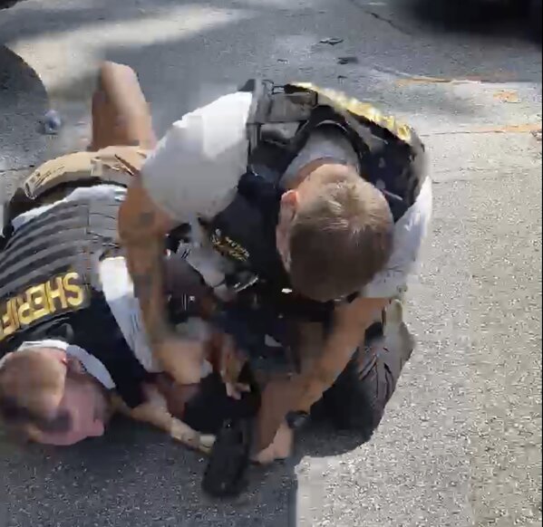 In this screen grab from video shot by Juanita Davis and provided by The Cochran Firm, a Clayton County, Ga., sheriff’s deputy holds down Roderick Walker while another deputy punches him while on the ground, Friday, Sept. 11, 2020, following a traffic stop. (Juanita Davis/Courtesy of The Cochran Firm via AP)
