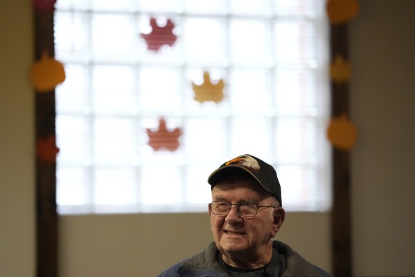 FILE - Earl Meyer, who fought for the U.S. Army in the Korean War, talks with fellow veterans at the American Legion, Nov. 7, 2023, in St. Peter, Minn. On Monday, April 22, 2024, the U.S. Army notified Meyer, who still carries shrapnel in his leg from when he was wounded in combat, that he will finally get his Purple Heart medal, 73 years late. (AP Photo/Abbie Parr, File)