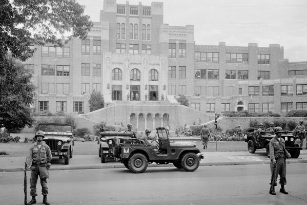 FILE - In this Sept. 26, 1957 file photo, members of the 101st Airborne Division take up positions outside Central High School in Little Rock, Ark. (AP Photo, File)