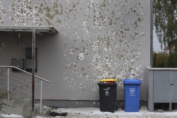 A house wall of an apartment building is damaged by hail in Kissing, Germany, Saturday Aug. 26, 2023. A storm with large hailstones damaged four-fifths of the buildings in a small town in the southern German state of Bavaria, local authorities said Sunday. The storm swept across the southern part of Bavaria on Saturday. In Kissing, just outside Augsburg, police said 12 people were injured when a beer tent that they were trying to put up was blown over. (Karl-Josef Hildenbrand/dpa via AP)