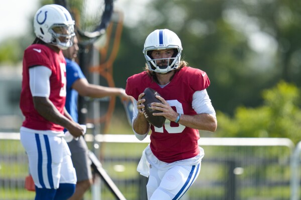 Indianapolis Colts quarterback Gardner Minshew II throws in front of Anthony Richardson during practice at the NFL team's football training camp in Westfield, Ind., Tuesday, Aug. 1, 2023. (AP Photo/Michael Conroy)