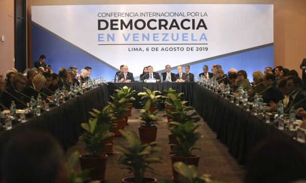 Peru's Foreign Ministry Nestor Nestor Popolizio, center, speaks during the inauguration of a conference of more than 50 nations that largely support Venezuelan opposition leader Juan Guaido in Lima, Peru, Tuesday, Aug. 6, 2019. During the meeting National Security Adviser John Bolton says the U.S. will target anybody at home or abroad who supports the government of Venezuelan President Nicolas Maduro with stiff financial sanctions. (AP Photo/Martin Mejia)