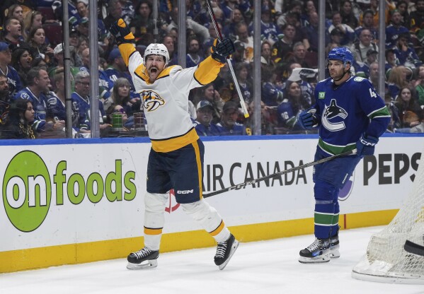 Nashville Predators' Filip Forsberg, left, celebrates his goal, next to Vancouver Canucks' Noah Juulsen during the second period in Game 2 of an NHL hockey Stanley Cup first-round playoff series Tuesday, April 23, 2024, in Vancouver, British Columbia. (Darryl Dyck/The Canadian Press via AP)