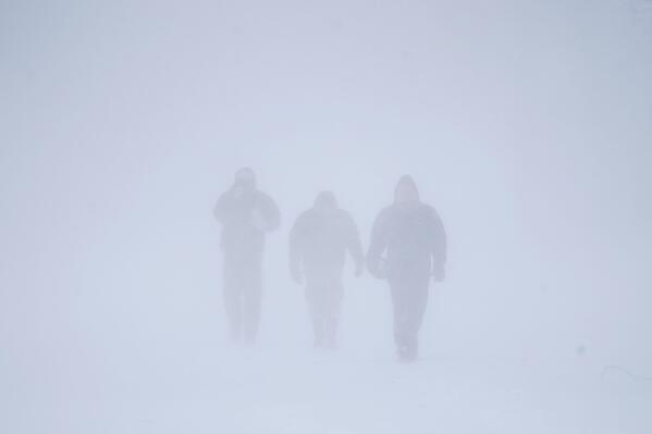 Three men walk down Richmond Avenue in whiteout conditions during a sustained blizzard in Buffalo, N.Y. on Saturday, Dec. 24, 2022. (Derek Gee/The Buffalo News via AP)