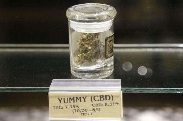 FILE - A jar of medical marijuana sits on a display case at the Thomas C. Slater Compassion Center in Providence, R.I., July 29, 2015. Rhode Island has become the latest state to allow recreational marijuana sales. Customers started lining up to buy recreational marijuana in the state on Thursday, Dec. 1, 2022, a little more than six months after Gov. Dan McKee signed the bill permitting such sales to people 21 and older into law. (AP Photo/Steven Senne, File)