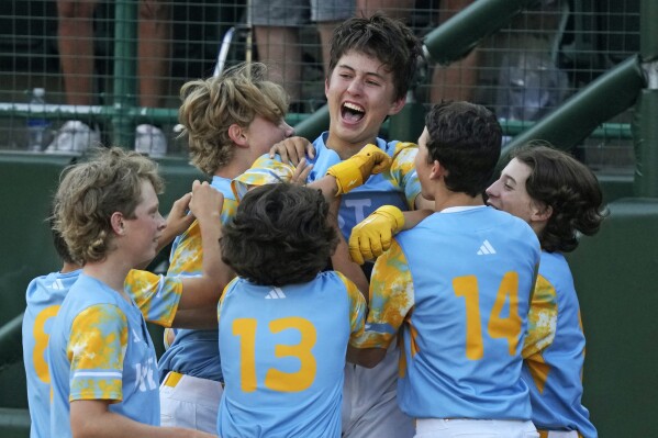 El Segundo, Calif.'s Louis Lappe, center, celebrates with teammates after hitting a solo walk-off home run off Curacao's Jay-Dlynn Wiel during the sixth inning of the Little League World Series Championship game in South Williamsport, Pa., Sunday, Aug. 27, 2023. California won 6-5. (AP Photo/Gene J. Puskar)