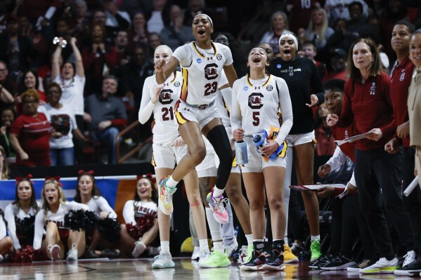 South Carolina forward Chloe Kitts (21), guard Bree Hall (23) and guard Tessa Johnson (5) react as their team scores against North Carolina during the first half of a second-round college basketball game in the women's NCAA Tournament in Columbia, S.C., Sunday, March 24, 2024. (AP Photo/Nell Redmond)