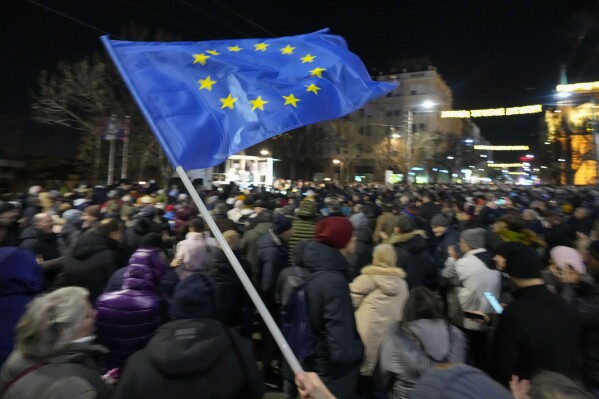 A protester waves an EU flag during a rally in downtown Belgrade, Serbia, Tuesday, Jan. 16, 2024. People rallied accusing the populist authorities of President Aleksandar Vucic of orchestrating a fraud during the Dec. 17 parliamentary and local election. The ruling Serbian Progressive Party was declared the election winner but the main opposition alliance, Serbia Against Violence, has claimed the election was stolen, particularly in the vote for the Belgrade city authorities. (AP Photo/Darko Vojinovic)