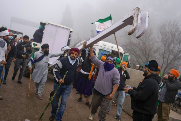 Indian farmers who have been protesting for a week to demand guaranteed crop prices wait to march to the capital near Shambhu border that divides northern Punjab and Haryana states, some 200 kilometers (120 miles) from New Delhi, India, Wednesday, Feb.21, 2024. The protesting farmers began their march last week, but their efforts to reach the city have been blocked by authorities. (AP Photo/Altaf Qadri)