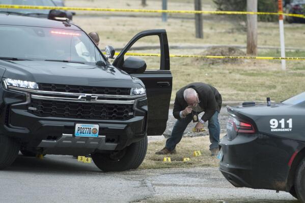 Investigators place evidence markers at the site of shootout involving police and a lone suspect Tuesday, March 8, 2022 near Ninth Street and Connecticut Avenue in Joplin, Mo. (Roger Nomer/The Joplin Globe via AP)