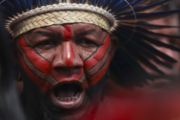 An Indigenous man attends the opening ceremony of the 20th annual Free Land Indigenous Camp in Brasilia, Brazil, April 22, 2024. The 7-day event aims to show the unity of Brazil's Indigenous peoples in their fight for the demarcation of their lands and their rights. (AP Photo/Luis Nova)