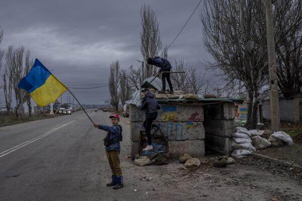 FILE - Ukrainian children play at an abandoned checkpoint in Kherson, southern Ukraine, Nov. 23, 2022. (AP Photo/Bernat Armangue, File)