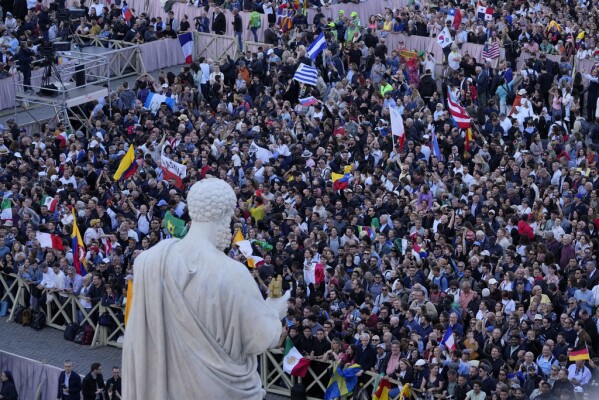 People wave flags in St. Peter's square after the election of the 267th pontiff of the Roman Catholic Church, at the Vatican, Thursday, May 8, 2025. (AP Photo/Gregorio Borgia)