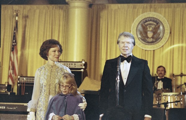 FILE - President Jimmy Carter, right; his wife Rosalynn Carter, left; and their daughter Amy, center, during a reception for the Democratic National Committee at the White House in Washington, Jan. 21, 1977. Former first lady Rosalynn Carter, the closest adviser to Jimmy Carter during his one term as U.S. president and their four decades thereafter as global humanitarians, has died at the age of 96. (AP Photo/Peter Bregg, File)