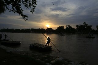 Un hombre navega por el río Suchiate entre Tecun Umán, Guatemala, y Ciudad Hidalgo, México, el lunes 17 de junio de 2019. (AP Foto/Rebecca Blackwell)