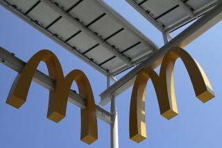 FILE- This Aug. 8, 2018, photo shows logos of McDonald's Chicago flagship restaurant. McDonald’s is raising pay at 650 company-owned stores in the U.S. as part of its push to hire thousands of new workers in a tight labor market. The fast food giant is the latest restaurant chain to announce pay raises. (AP Photo/Nam Y. Huh, File)