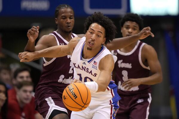 Kansas forward Jalen Wilson (10) beats Texas Southern forward Davon Barnes (2) and guard PJ Henry (3) to a loose ball during the first half of an NCAA college basketball game Monday, Nov. 28, 2022, in Lawrence, Kan. (AP Photo/Charlie Riedel)