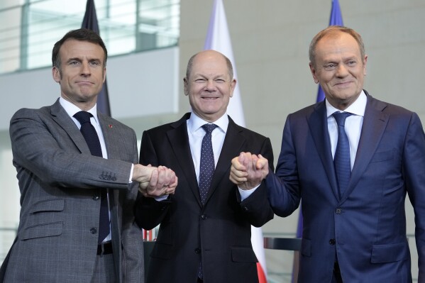 German Chancellor Olaf Scholz, center, French President Emmanuel Macron, left, and Poland's Prime Minister Donald Tusk shake hands at a press conference in Berlin, Germany, Friday, March 15, 2024. German Chancellor Olaf Scholz, France's President Emmanuel Macron and Poland's Prime Minister Donald Tusk meet in Berlin for the so-called Weimar Triangle talks. (AP Photo/Ebrahim Noroozi)