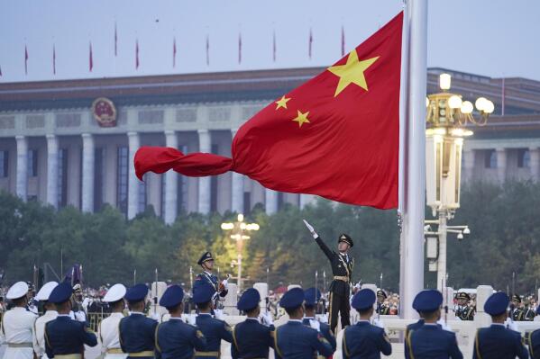 FILE - In this photo released by Xinhua News Agency, a member of the Chinese honor guard unfurls the Chinese national flag during a flag raising ceremony to mark the 73rd anniversary of the founding of the People's Republic of China held at the Tiananmen Square in Beijing on Oct. 1, 2022. Leaders of the Group of Seven advanced economies are generally united in voicing concern about China. The question is how to translate that worry into action.(Chen Zhonghao/Xinhua via AP, File)