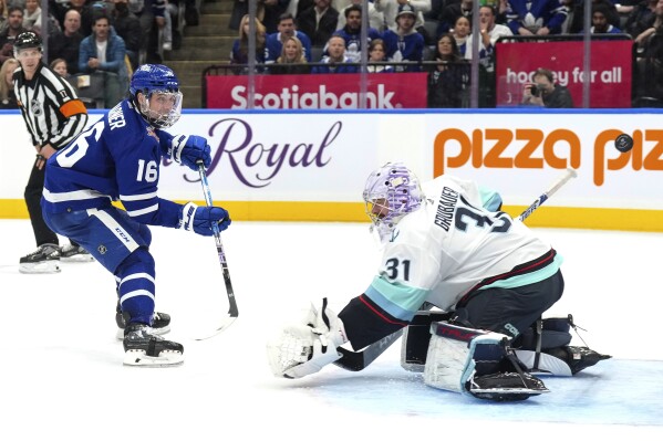 Toronto Maple Leafs' Mitchell Marner scores against Seattle Kraken goaltender Philipp Grubauer during the second period of an NHL hockey game Thursday, Nov 30, 2023, in Toronto. (Chris Young/The Canadian Press via AP)