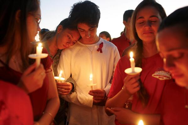 Students gather during a vigil at Pine Trails Park for the victims of the Wednesday shooting at Marjory Stoneman Douglas High School, in Parkland, Fla., Thursday, Feb. 15, 2018. Nikolas Cruz, a former student, was charged with 17 counts of premeditated murder on Thursday. (AP Photo/Brynn Anderson)