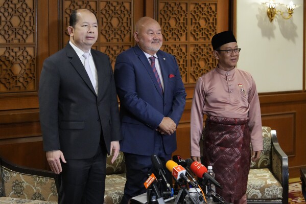 Zulkifli Zainal Abidin, Malaysia's facilitator of peace talks for southern Thailand, center, Chatchai Bangchaud, from Southern Border Provinces of Thailand (PEDP), left, and Ustaz Anas Abdul Rahman from Barisan Revolution Nasional Melayu Patani (BRN) pose for a picture after a press conference at a hotel in Kuala Lumpur, Malaysia Wednesday, Feb. 7, 2024. (AP Photo/Vincent Thian)