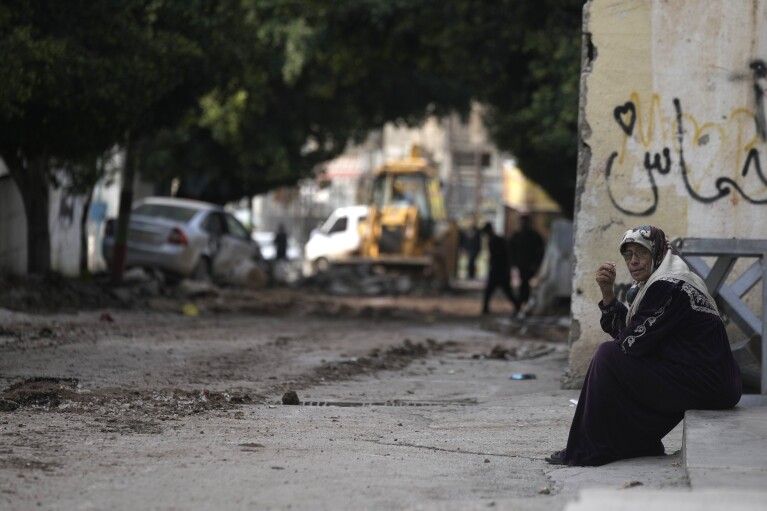 A woman sits near the site where three Palestinians were killed by Israeli fire in Faraa refugee camp near the West Bank town of Tubas, Tuesday, Feb. 27, 2024. Israeli troops shot and killed three Palestinian men including Mohamed Daraghmeh, a co-founder of the local branch of the Islamic Jihad militant group, in the northern town of Tubas, early Tuesday, Palestinian health authorities said. Thee was no immediate comment from the Israeli military. (AP Photo/Majdi Mohammed)