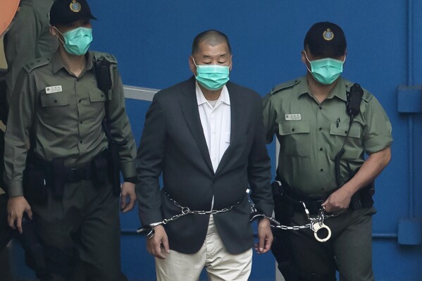 FILE - Jimmy Lai is escorted by Correctional Services officers to get on a prison van before appearing in a court in Hong Kong, Dec. 12, 2020. On Thursday, Feb. 1, 2024, two U.S. lawmakers announced a nomination for Lai, a former Hong Kong publisher now standing trial on national security charges, and three other jailed Chinese dissidents, for the Nobel Peace Prize. While hundreds of people are often nominated for the annual prize, this nomination is certain to draw a sharp rebuke from Beijing. (AP Photo/Kin Cheung, File)