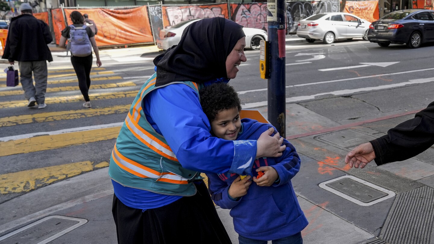 С жилетка и глас помощници ескортират деца през разбитите улици на Сан Франциско