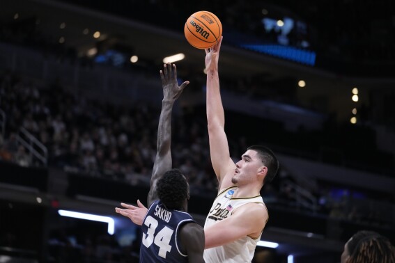 Purdue's Zach Edey shoots over Utah State's Kalifa Sakho (34) during the second half of a second-round college basketball game in the NCAA Tournament, Sunday, March 24, 2024 in Indianapolis. (AP Photo/Michael Conroy)