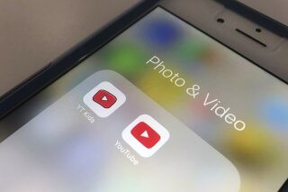 FILE - In this Wednesday, April 25, 2018, file photo, the YouTube app and YouTube Kids app are displayed on a smartphone in New York. A new survey confirms what a lot of parents already know: Teens...