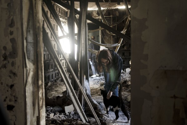 Sharon Alony Cunio is reunited with her cat, Elvis, on Monday, Jan. 15, 2024, in the ruins of her home in Kibbutz Nir Oz from where she was kidnapped with her daughters and husband on Oct. 7, 2023, by Hamas militants. Her husband is among scores of captives believed to be alive in Gaza, after 120 hostages, including his wife and daughters, were freed during a weeklong cease-fire in November. (AP Photo/Maya Alleruzzo)