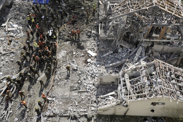 Firefighters, rescue workers and military gather at the site of a direct missile strike launched from Iran in Tel Aviv, Israel, on Sunday, June 22, 2025. (AP Photo/Oded Balilty)