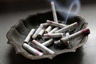 FILE - In this Saturday, March 2, 2013 file photo, a cigarette burns in an ashtray in Hayneville, Ala. Anti-smoking advocates are warning that the stress and disruptions of the COVID-19 pandemic may have slowed efforts to get more Americans to quit in 2020. (AP Photo/Dave Martin)