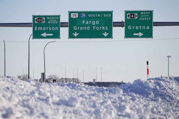 FILE - Road signage is posted just outside of Emerson, Manitoba, Jan. 20, 2022. A second man, Harshkumar Ramanlal Patel, is now facing federal charges connected with a human smuggling operation in which a family of four from India froze to death at the border of Canada and Minnesota. Patel was arrested Wednesday, Feb. 21, 2024, in Chicago. (John Woods/The Canadian Press via AP, File)