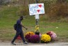 FILE - A man walks by flowers and a sign of support for the community, Oct. 28, 2023, in the wake of the mass shootings that occurred on Oct. 25, in Lewiston, Maine. The Maine Legislature has approved sweeping gun safety legislation early Thursday, April 18, 2024, nearly six months after the deadliest shooting in state history. (AP Photo/Robert F. Bukaty, File)