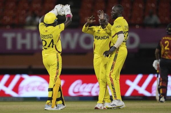 Uganda's captain Brian Masaba, center, celebrates with teammates Robinson Obuya and Simon Ssesazi after taking the wicket of Papua New Guinea's Chad Soper during an ICC Men's T20 World Cup cricket match at Guyana National Stadium in Providence, Guyana, Wednesday, June 5, 2024. (AP Photo/Ramon Espinosa)