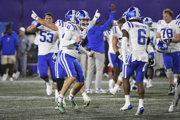 Duke punter Kade Reynoldson (41) celebrates with safety Leon Griffin III (6) after beating Northwestern at the end of the second overtime period of an NCAA college football game, Friday, Sept. 6, 2024, in Evanston, Ill. (AP Photo/Matt Marton)