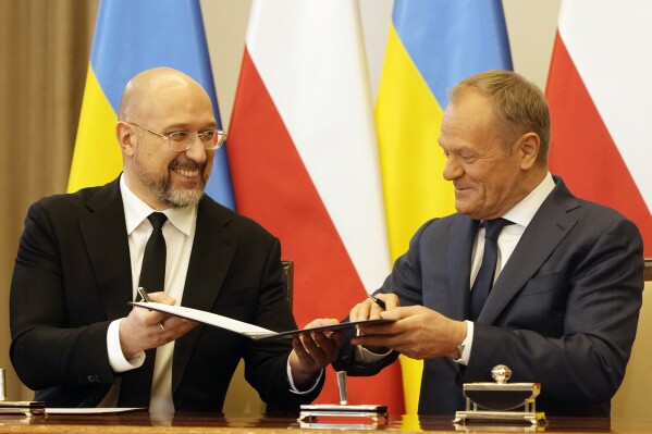 Poland's Prime Minister Donald Tusk, right, and Ukraine's Prime Minister Denys Shmyhal sign documents after bilateral meetings at the Chancellery of Prime Minister in Warsaw, Poland, Thursday, March 28, 2024. (AP Photo/Czarek Sokolowski)