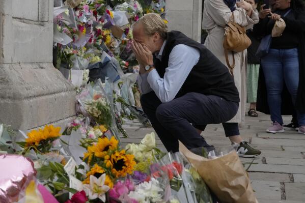 A mourners is overcome with emotion as he pays his respect at the gates of Buckingham Palace in London, Friday, Sept. 9, 2022. Queen Elizabeth II, Britain's longest-reigning monarch and a rock of stability across much of a turbulent century, died Thursday Sept. 8, 2022, after 70 years on the throne. She was 96. (AP Photo/Kirsty Wigglesworth)