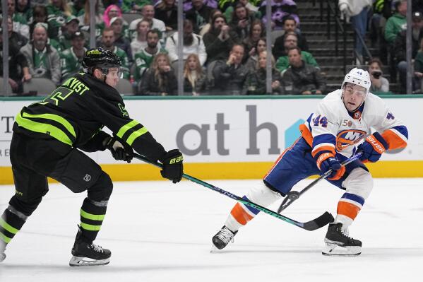Dallas Stars defenseman Nils Lundkvist (5) and New York Islanders center Jean-Gabriel Pageau (44) compete for control of the puck in the second period of an NHL hockey game Saturday, Nov. 19, 2022, in Dallas. (AP Photo/Tony Gutierrez)