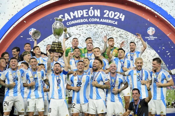 Players of Argentina celebrate with the trophy after defeating Colombia in the Copa America final soccer match in Miami Gardens, Fla., Monday, July 15, 2024. (AP Photo/Rebecca Blackwell)