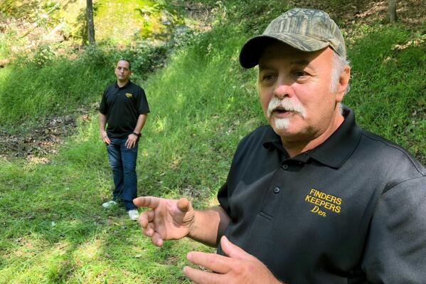 FILE - In this Sept. 20, 2018 photo, Dennis Parada, right, and his son Kem Parada stand at the site of the FBI's dig for Civil War-era gold in Dents Run, Pa. Treasure hunters who claim the FBI made off with several tons of buried Civil War-era gold are now questioning whether evidence related to the 2018 excavation in Pennsylvania has been destroyed. Finders Keepers, which sued the Justice Department over its failure to produce records on the FBI’s search for the legendary gold, said in a court filing Friday, March 18, 2022, that the FBI initially said its records of the dig included 17 video files. (AP Photo/Michael Rubinkam, File)
