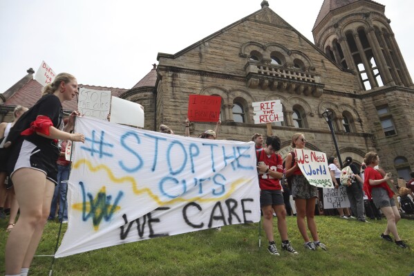 FILE - West Virginia University students lead a protest against cuts to programs in world languages, creative writing and more amid a $45 million budget deficit, Aug. 21, 2023, outside Stewart Hall in Morgantown, W.Va. (AP Photo/Leah Willingham, File)