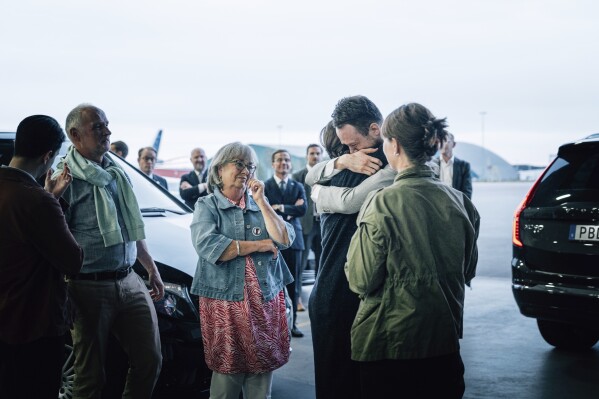 In this photo provided by the Swedish government, Johan Floderus reunites with his family at Arlanda airport in Stockholm, Sweden on Saturday, June 15, 2024, after being released from prison in Iran. (Tom Samuelsson/Swedish government/TT News Agency via AP)