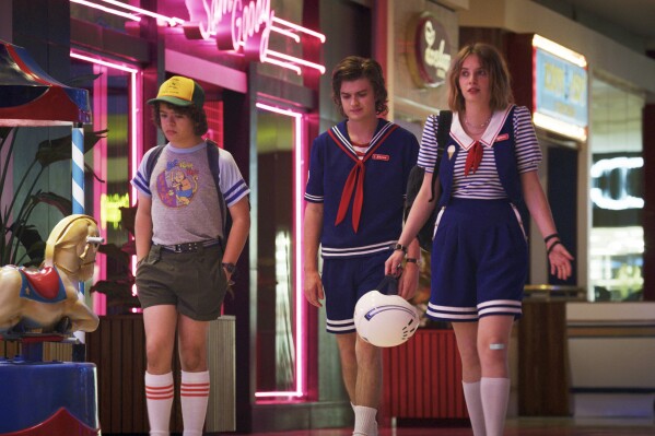 This image released by Netflix shows, from left, Gaten Matarazzo, Joe Keery, and Maya Hawke in a scene from "Stranger Things." The scene was shot on location at the Gwinnett Place Mall in Duluth, Ga. (Netflix via AP)