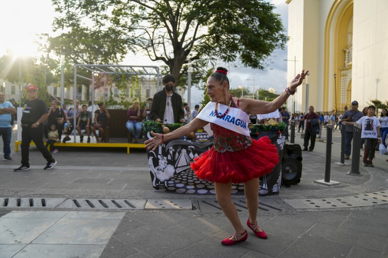 Street artist "Yagira" A Miss Nicaragua sash dances in Gerardo Barrios Square in San Salvador, El Salvador, Friday, November 17, 2023. El Salvador is hosting the 72nd Miss Universe pageant. The contest is the latest spectacle promoted by President Nayib Bukele in his efforts to change the reputation of his nation, which has been historically riven by violence. (AP Photo/Moises Castillo) (AP Photo/Moises Castillo)
