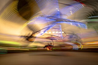 A person enjoys a ride at a fair in Hagioaica, Romania, Saturday, Sept. 16, 2023. For many families in poorer areas of the country, Romania's autumn fairs, like the Titu Fair, are one of the very few still affordable entertainment events of the year. (AP Photo/Alexandru Dobre)