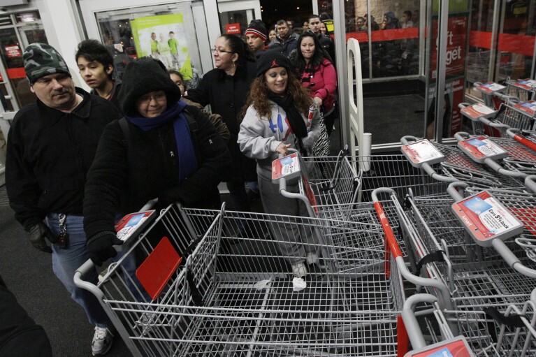 FILE - Shoppers rush into a Kmart store in Chicago on on Nov. 25, 2011 for Black Friday sale. (AP Photo/Nam Y. Huh, File)
