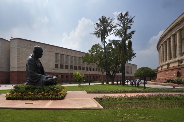 FILE - A statue of Mahatma Gandhi sits between the old and new Parliament House buildings on the opening day of the monsoon session of the Indian parliament, in New Delhi, India, Thursday, July 20, 2023. Indian lawmakers have approved a data protection legislation that seeks to better regulate big tech firms and penalize companies for data breaches. The Digital Personal Data Protection bill was passed by the upper house of Parliament Wednesday amid concerns by opposition parties and digital experts who said it undermines the privacy rights of Indians. (AP Photo/Manish Swarup, File)